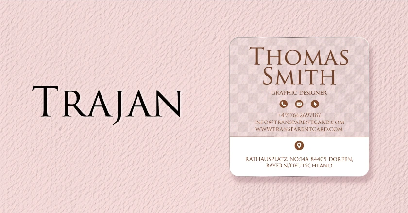 A transparent business card mockup featuring the Trajan font.